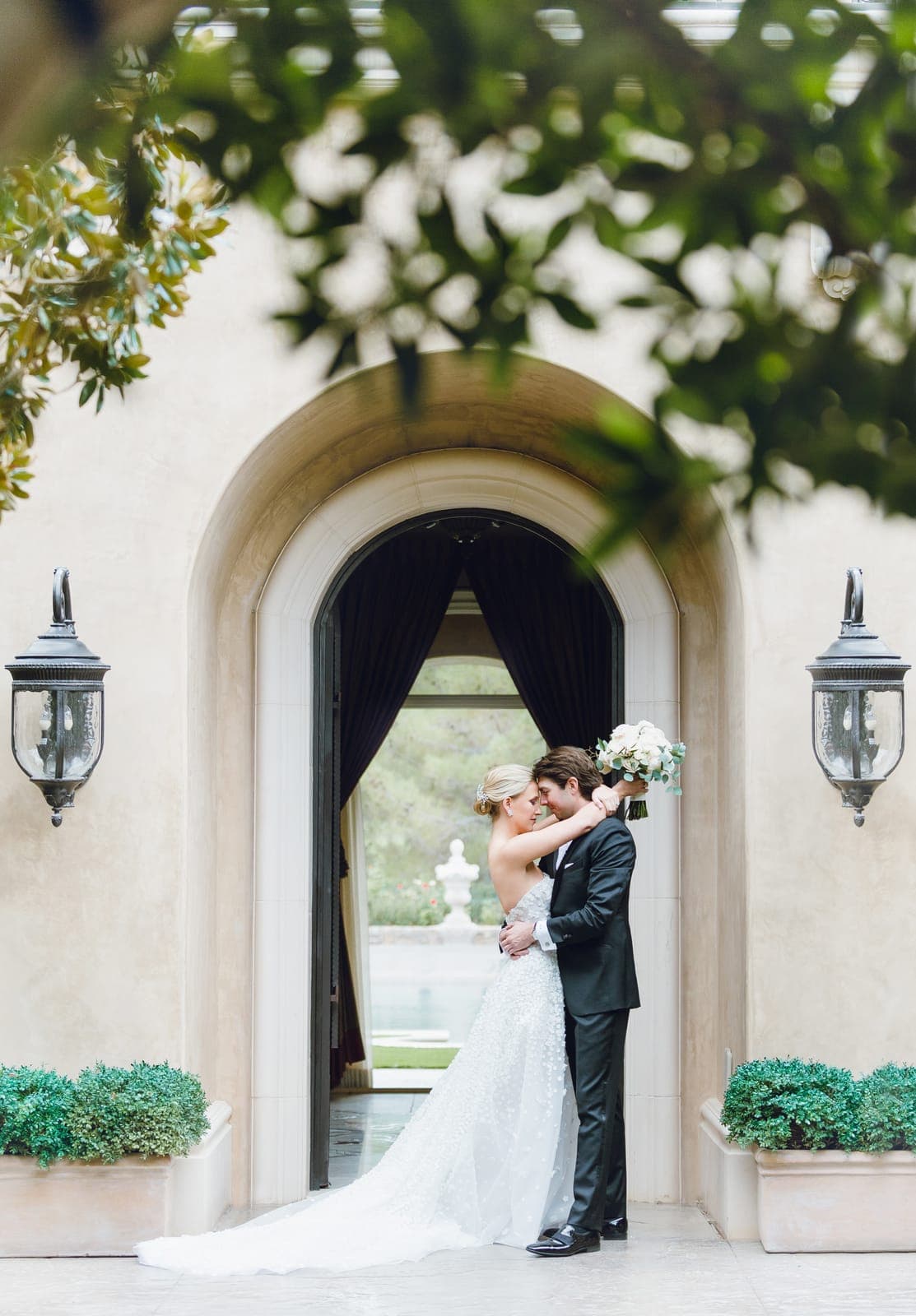 A couple embracing beneath the lantern-lit stone archway at Southern Highlands on their wedding day